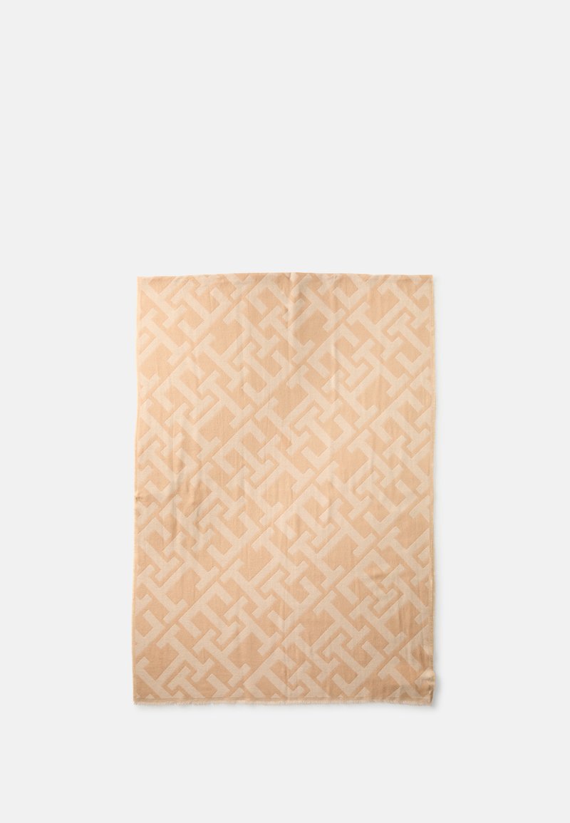 Beige woven blanket featuring a geometric pattern in a slightly lighter shade, with a soft texture and fringe detailing on the edges.