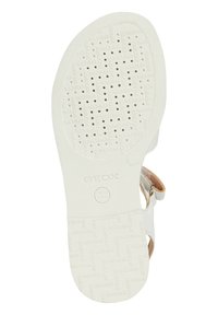 Sandalia blanca con una suela de goma texturizada y con patrón. Incluye perforaciones para la transpirabilidad y una correa con un acento metálico.