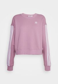 Rosa kortärmad sweatshirt i mjukt material. Har vita tre-strecks detaljer på ärmarna och en liten vit logotyp på bröstet.