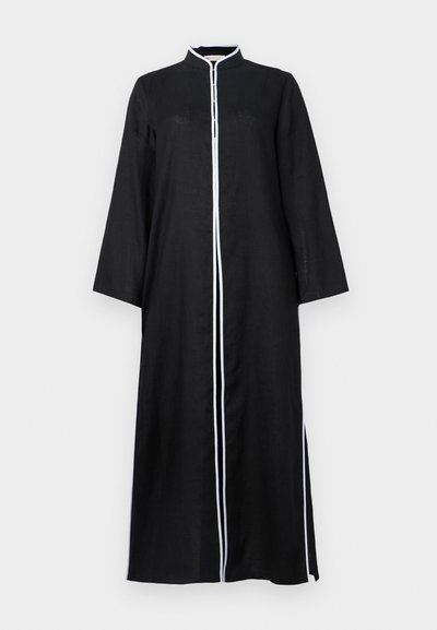 Črna dolga obleka z dolgimi rokavi in visokim ovratnikom, ki ima beli obrobo ob sprednji strani in stranske razpoke, izdelana iz lahkega materiala.