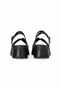 Sandales noires avec une plateforme épaisse, dotées de brides réglables et d'un dessus texturé avec des accents métalliques. Matériau en cuir lisse.