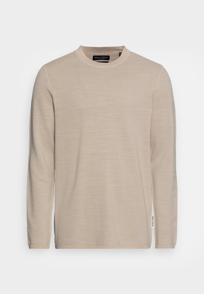 Pull beige à manches longues avec col rond, texture en maille côtelée et petite étiquette en tissu sur la couture latérale inférieure.
