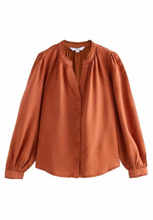 Rust-colored blouse with a round neckline, button closure, and long puffed sleeves. Made of smooth fabric with a gathered detail at the collar.