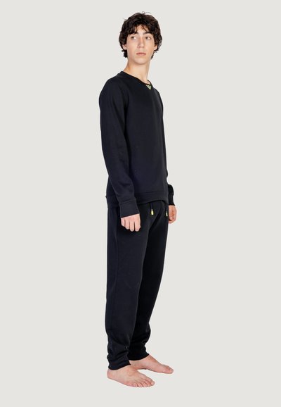 Felpa nera a maniche lunghe e pantaloni coordinati in tessuto morbido. La felpa ha un collo a girocolo; i pantaloni presentano un laccio e tasche.