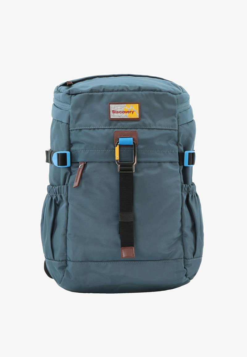 Mochila de tela azul oscuro con un parche de logo, hebilla ajustable, correas frontales y bolsillos laterales. Textura suave con un diseño compacto.