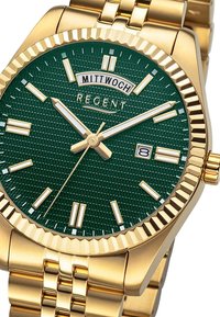 Montre en or avec un cadran vert texturé, des index horaires blancs et un affichage de la date. Elle possède un bracelet métallique en or avec une lunette striée.