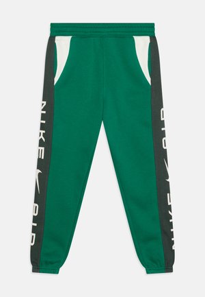 Pantalones de chándal verdes con bolsillos laterales blancos y paneles laterales de color gris oscuro. Presenta la atrevida inscripción "NIKE AIR" en blanco en la pierna izquierda.