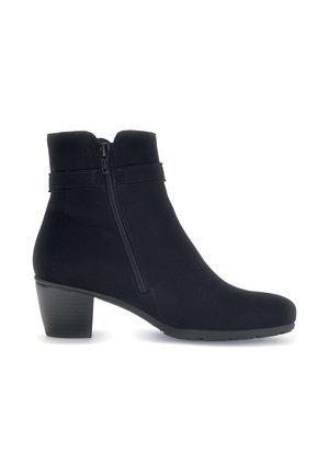 Bottine noire en tissu doux avec une fermeture éclair sur le côté, coupe droite et petit talon carré. Texture lisse et détails minimaux.