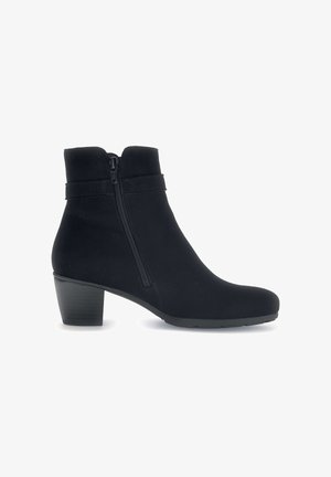Bottine noire en tissu doux avec une fermeture éclair sur le côté, coupe droite et petit talon carré. Texture lisse et détails minimaux.