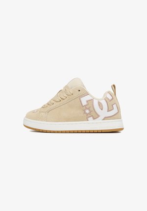 Sneaker beige basso con suola in gomma bianca e marrone chiaro, lacci, linguetta in mesh e grande logo DC sul pannello laterale.