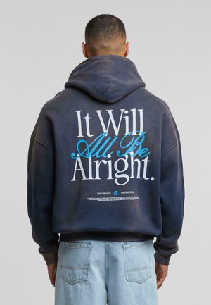 Sudadera azul marino con capucha ajustable y puños acanalados. La parte posterior presenta un gran texto en blanco y azul: "Todo estará bien."