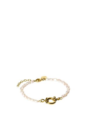 Zarter Armband mit weißen Perlen und einem goldenen runden Verschluss, mit verstellbarer Goldkette und einem kleinen gravierten Anhänger.
