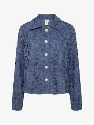 Tumši zila mežģīņu jaka ar ziedu rakstiem, strukturētu apkakli un piecām pērļu līdzīgām pogām. Tekstūrēta auduma ar sarežģītiem izgriezumiem.