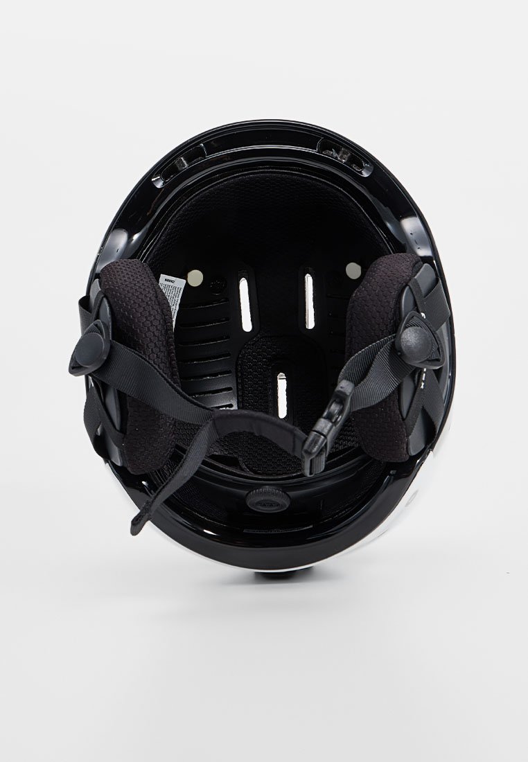 Czarna wyściółka kasku z teksturowanym wypełnieniem, regulowanymi paskami, otworami wentylacyjnymi oraz okrągłym pokrętłem do regulacji dopasowania.