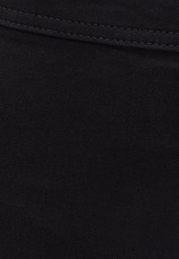 Černá tkanina s hladkou texturou a lehkým leskem. Viditelné švy podél okrajů s konzistentním vzorem a dokončením.