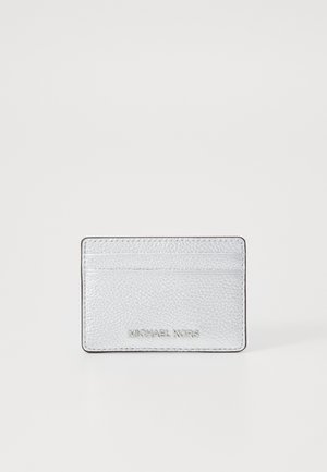 Portafoglio in pelle argentata con finitura texturizzata, dotato di tre slot per carte e con il marchio "MICHAEL KORS" impresso sul frontale.