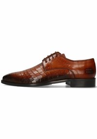 Chaussure habillée en cuir marron avec une texture crocodile, présentant un bout pointu, un laçage et une semelle plate en caoutchouc noir.