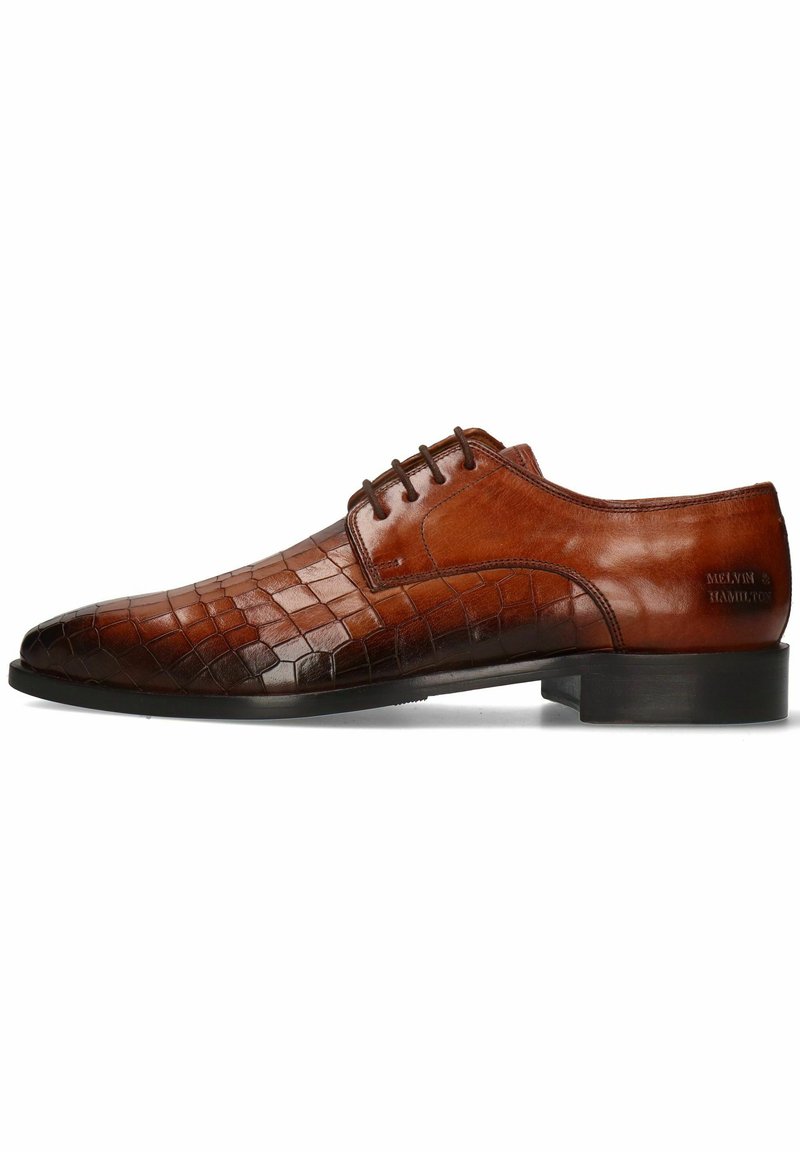 Chaussure habillée en cuir marron avec une texture crocodile, présentant un bout pointu, un laçage et une semelle plate en caoutchouc noir.