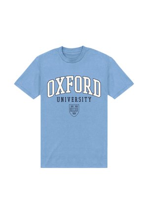 Camiseta de manga corta azul claro con "OXFORD UNIVERSITY" en grandes letras blancas y negras y un pequeño escudo universitario negro debajo del texto.