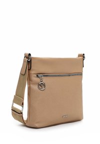 Borsa a tracolla in pelle perforata beige con cerniera argentata e ciondolo decorativo a simbolo di pace, dotata di tracolla in tessuto regolabile.