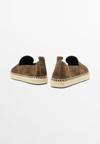 Brune ruskind slip-on sko med en struktureret overflade og subtil syning. Indeholder en sål af jute reb og en bageste trækstrop for nem påtagning.