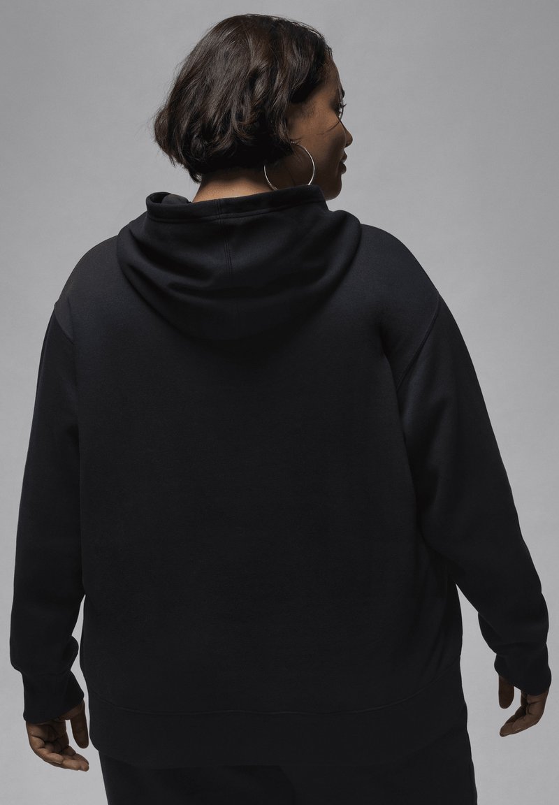 Sweat-shirt à capuche noir avec une texture douce, doté d'une coupe décontractée, d'une poche kangourou à l'avant et de poignets et d'ourlet côtelés.