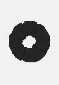 Scrunchie in tessuto nero con una finitura testurizzata, dotata di un elastico che crea un aspetto arricciato attorno a una forma circolare.