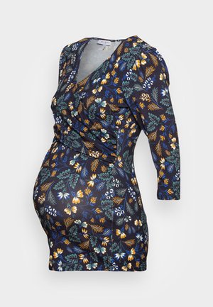 Granatowa sukienka ciążowa z kopertowym fasonem, rękawami 3/4 i wielokolorowym kwiatowym wzorem w odcieniach żółci, zieleni, bieli i niebieskiego.