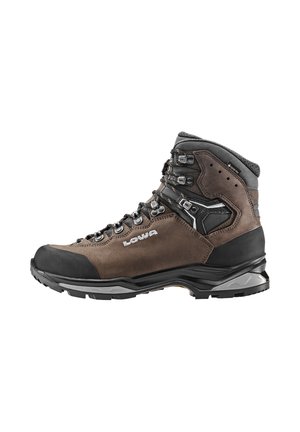 Wanderschuhe mit einem Obermaterial aus braunem Wildleder, schwarzem Gummispitzenschutz, silbernen Metallösen, verstärkter Knöcherunterstützung und einer strukturierten Außensohle.