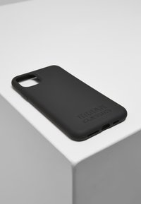 Carcasa pentru telefon din silicon negru, cu un finisaj mat texturat, decupaje pentru cameră și porturi, logo embosat cu textul "Urban Classics."