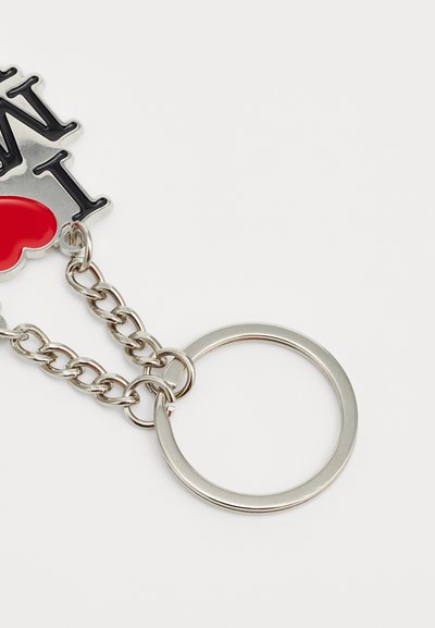 Přívěsek na klíče s designem "I ♥ NY" v černé a červené barvě. Vyroben z kovu s řetízkem ve stříbrném tónu a kulatým rozděleným kroužkem pro připevnění.