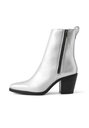 Silberne Knöchelstiefel mit spitzer Zehe, glatter Lederoberfläche, seitlichem Reißverschluss und einem massiven schwarzen Absatz.