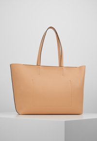 Hnědá kožená taška přes rameno s černými detaily. Obsahuje dvě ucha a minimalistický design s jemným švem a obdélníkovým tvarem.