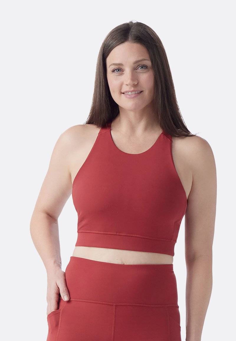 Röd aktivklädnad crop top med hög halsringning, figurnära design och slät textur. Den har breda axelremmar och en avrundad nederkant.