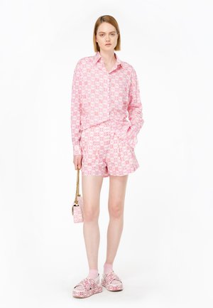 Set di camicia a maniche corte e pantaloni corti con motivo rosa, realizzato in tessuto leggero. Abbinato a scarpe slip-on rosa e una mini borsa coordinata.