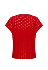 Haut rouge à manches courtes avec un design en œillets décoratifs comprenant des formes de diamant et des points ouverts, créant une texture légère et aérée.