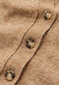 Cardigan marrone lavorato a maglia con tessuto testurizzato, cinque bottoni con motivo marmorizzato e un aspetto leggermente mélange.