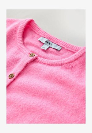 Jasnoróżowy wełniany kardigan z okrągłym dekoltem, z zapięciem na guziki i miękką, teksturowaną powierzchnią. Widoczna metka marki.