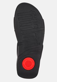 Zwarte rubberen sandaalzool met een gemarmerd grip patroon, met een opvallende rode cirkelvormige accent gemarkeerd met "WOBBLEBOARD." Het ontwerp bevat branding.