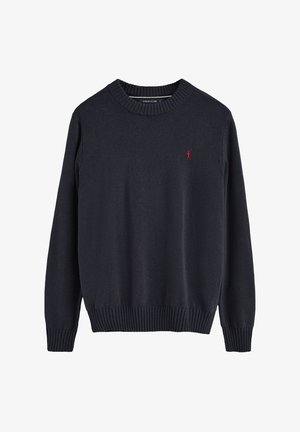 Ciemnoniebieski wełniany sweter z prążkowanym dekoltem w kształcie łódki i mankietami. Z przodu znajduje się małe czerwone logo po lewej stronie klatki piersiowej. Gładka tekstura, klasyczny krój.