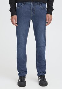 Jeans hlače iz temno modrega jeansa z ravnim krojem hlačnic, kontrastnim šivom, pet žepnim dizajnom in zapiranjem z gumbom v pasu.