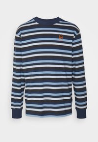 Navy, vaaleansininen ja valkoinen raidallinen pitkähiha-paita. Varustettu ribbauslahkeilla ja pienellä oranssilla logolla rinnassa. Puuvillamateriaalia.