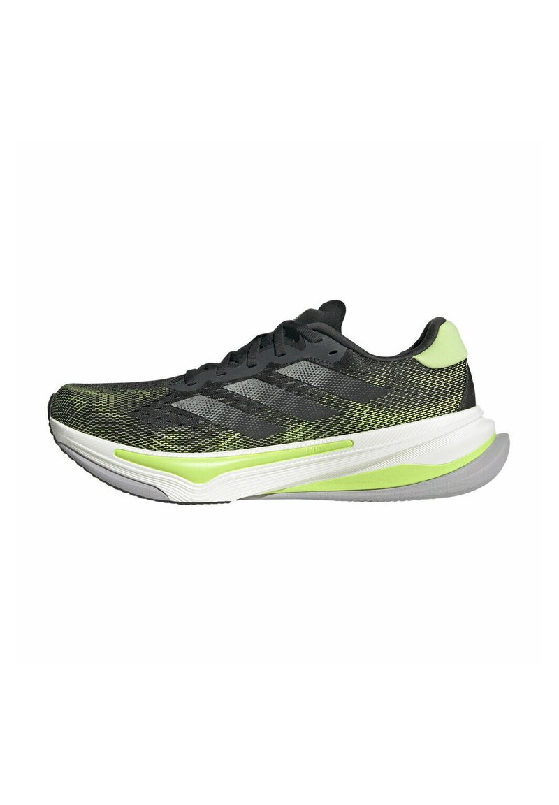 Scarpe da corsa con una tomaia in rete nera e verde, dotate di tre strisce nere, una suola verde e una intersuola bianca con un motivo testurizzato.