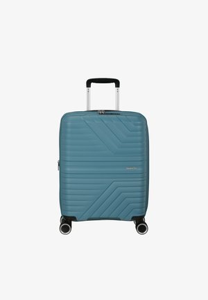 Valise rigide bleu sarcelle avec des lignes diagonales texturées, poignée télescopique déployée et quatre roues pivotantes, vue de face.