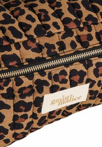 Tela acolchada con un estampado de leopardo en tonos marrón y negro, cierre dorado y etiqueta blanca con el texto "grain de malice".