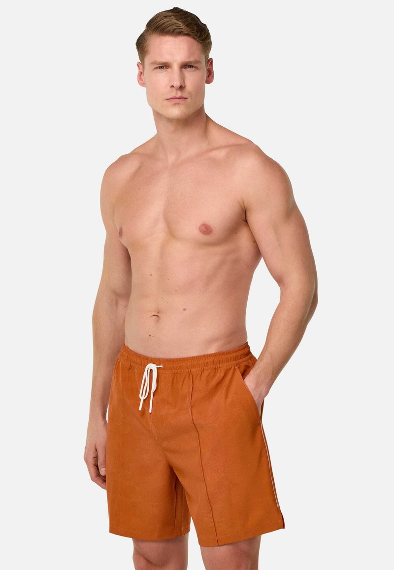 Vīriešu oranži peldšorti ar elastīgu jostu un baltu auklu, ar sānu kabatām un gludu, teksturētu audumu.