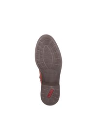 Semelle en caoutchouc brun avec un motif de grip texturé, arborant un logo circulaire et un design à bout arrondi. Comprend une indication de taille "37" près du talon.