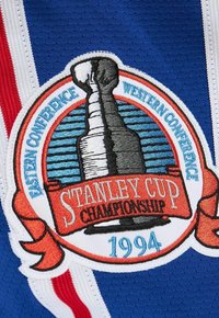 Auf blauem Stoff befindet sich ein Patch, der den Stanley Cup zeigt, zusammen mit den Beschriftungen "Eastern Conference", "Western Conference", "Stanley Cup Championship" und "1994".