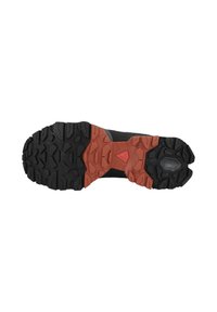 Schwarze und rote Laufsohle eines Sportschuhs mit einem strukturierten Gummidesign, das tiefe Rillen für Traktion und einen auffälligen roten Akzent aufweist.