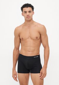 Schwarze Boxershorts aus weichem Stoff, mit einem Logo-Bund und einer engen Passform, die ein einfaches und klassisches Design präsentieren.
